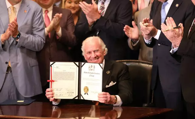 2026年4月15日周三，南卡羅來納州哥倫比亞，共和黨籍南卡羅來納州州長亨利麥克馬斯特手持一份簡化州稅法並設定所得稅率減免框架的法案儀式性副本。(美聯社圖片/傑弗里·科林斯) AP圖片