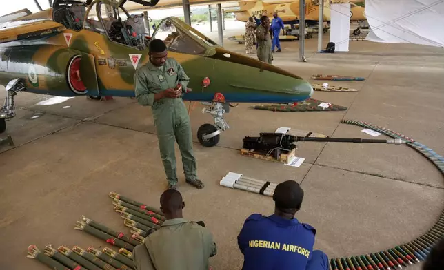 (美聯社圖片/Sunday Alamba) 檔案圖片：2017年4月22日，尼日利亞空軍人員在尼日利亞馬庫爾迪（Makurdi）一場活動中，於一架戰機旁展示彈藥。 AP圖片