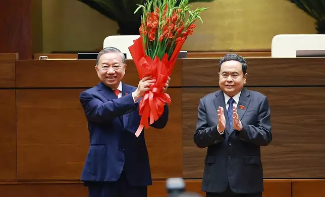2026年4月7日周二，越南最高領導人蘇林（左）在河內宣誓就任國家主席後，從國會主席陳清敏（Tran Thanh Man）手中接過花束。(美聯社圖片/楊文江/越南通訊社) AP圖片