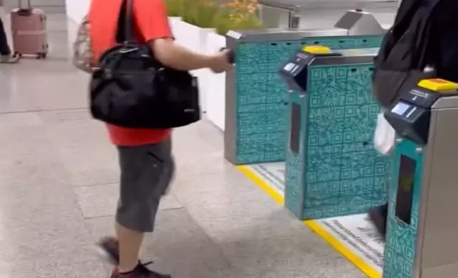 一名身穿紅衣並戴著口罩的男子，在青衣港鐵站緊跟著前方一位黑衣男子入閘。Threads截圖