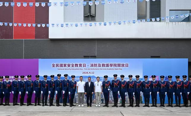 財政司司長陳茂波（中）、消防處副處長（行動）陳慶勇（右十四）和消防及救護學院院長黃思律（左十四）與消防處儀仗隊合照。 政府新聞處圖片