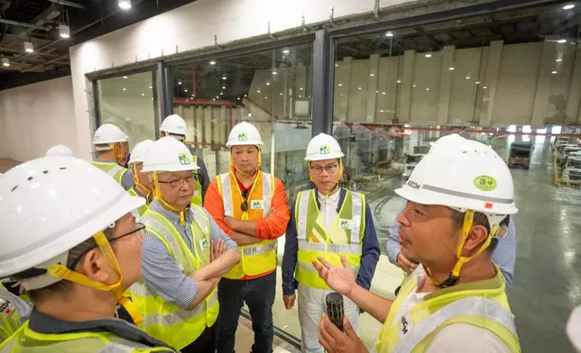 謝展寰（左二）及立法會議員視察廢物傾卸大堂的運作。政府新聞處圖片