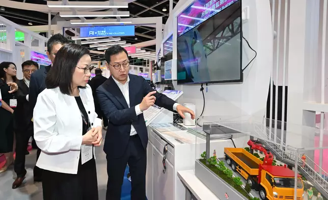 謝詠誼（左）了解吊臂高度及位置監測系統如何保障行車和道路安全。政府新聞處圖片