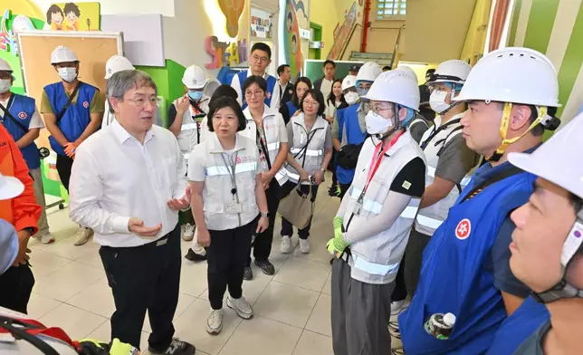 政務司副司長卓永興22日視察大埔宏福苑居民上樓安排。圖示卓永興（左一）在大埔浸信會公立學校，為正準備出發的駐樓層專隊打氣。旁為社會福利署副署長（服務）梁綺莉（左二）。政府新聞處圖片