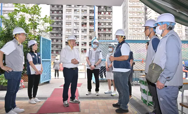 卓永興（左三）在大埔浸信會公立學校，向地區服務及關愛隊伍隊員支援上樓居民，表達謝意。政府新聞處圖片