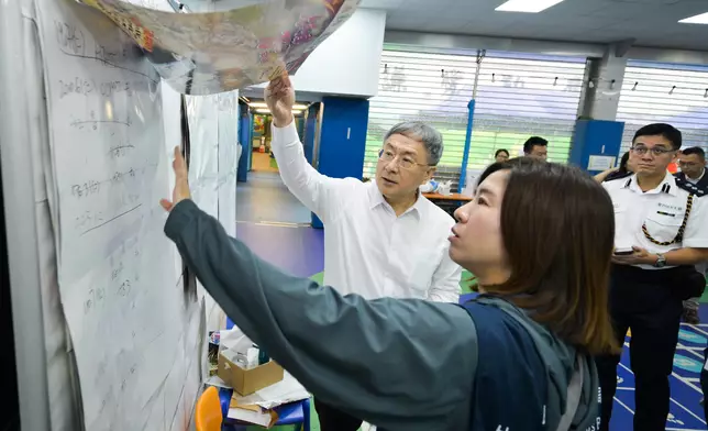 卓永興（左一）聽取王婉蓉（左二）講述安排預約車輛的工作。政府新聞處圖片