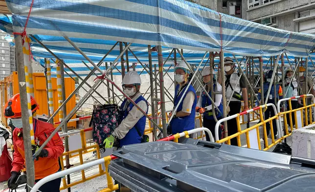 來自地政總署的動員公務員聯同民眾安全服務隊隊員和地區服務及關愛隊伍義工，協助大埔宏福苑上樓居民搬運物品落樓。政府新聞處圖片