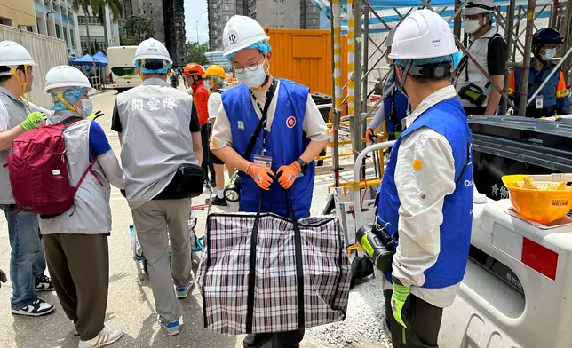 動員公務員、民眾安全服務隊隊員和地區服務及關愛隊伍義工，協助大埔宏福苑上樓居民搬運物品。政府新聞處圖片