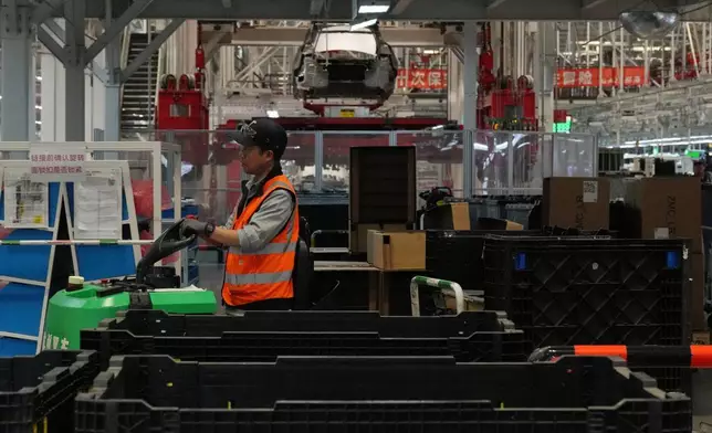 2026年4月14日周二，在中國上海，一名工人在特斯拉超級工廠（Gigafactory）組裝廠的特斯拉Model Y生產線上轉移部件，當時正進行媒體參觀活動。(美聯社圖片/Andy Wong) AP圖片