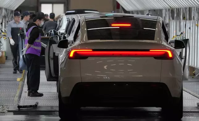 2026年4月14日周二，在中國上海，工人在特斯拉超級工廠（Gigafactory）組裝廠檢查特斯拉Model Y，當時正進行媒體參觀活動。(美聯社圖片/Andy Wong) AP圖片