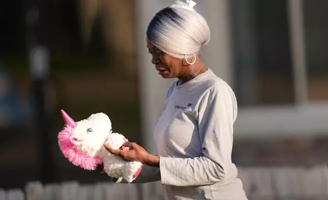 一名女子抵達路易斯安那州什里夫波特（Shreveport）大規模槍擊案現場時，手持一隻獨角獸毛絨玩具。攝於2026年4月19日周日。(美聯社圖片/Gerald Herbert) AP圖片