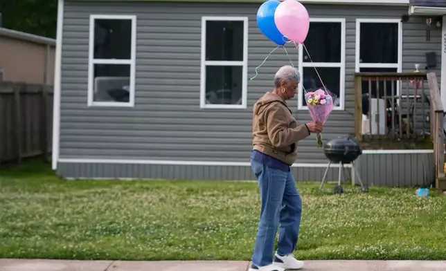 一名女子在路易斯安那州什里夫波特（Shreveport）前一天發生大規模槍擊案、兒童遇害的房屋前草坪上，放置鮮花和氣球。攝於2026年4月20日周一。(美聯社圖片/Gerald Herbert) AP圖片