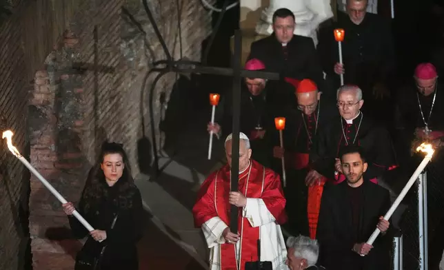 教宗利奧十四世於2026年4月3日周五，在羅馬鬥獸場舉行的苦路（Via Crucis）燭光耶穌受難日（Good Friday）遊行期間，背負一個輕巧的1.5米木製十字架，象徵性地重現耶穌基督在耶路撒冷各各他（Calvary）被釘十字架的歷程。(美聯社圖片/亞歷山德拉·塔蘭蒂諾 Alessandra Tarantino) AP圖片