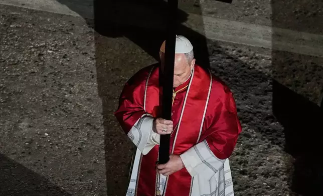 教宗利奧十四世於2026年4月3日周五，在羅馬鬥獸場舉行的苦路（Via Crucis）燭光耶穌受難日（Good Friday）遊行期間，背負一個輕巧的1.5米木製十字架，象徵性地重現耶穌基督在耶路撒冷各各他（Calvary）被釘十字架的歷程。(美聯社圖片/亞歷山德拉·塔蘭蒂諾 Alessandra Tarantino) AP圖片