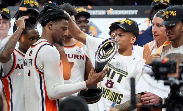 奧本後衛奧弗頓（左）在2026年4月5日周日於印第安納波利斯舉行的NCAA大學籃球NIT冠軍賽中，擊敗塔爾薩後手持獎盃。(美聯社圖片/Abbie Parr) AP圖片