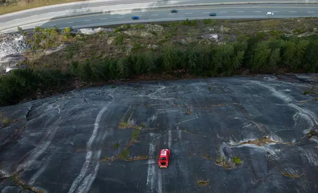 2026年4月6日周一，卑詩省史夸米殊（Squamish）的「海天公路」（Sea-to-Sky Highway）上方懸掛著一輛福士甲蟲車（Volkswagen Beetle）的車殼。該車殼上周出現在岩壁上，車頂有一個大大的「E」字，顯示卑詩大學（University of British Columbia）工程系學生延續了將車殼放置在難以到達地點的傳統。(美聯社圖片/Darryl Dyck/The Canadian Press) AP圖片