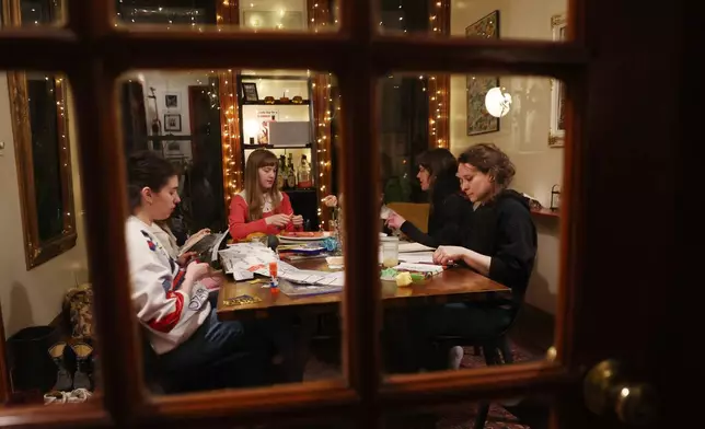 2026年3月25日周三，在紐約布魯克林區（Brooklyn）的活動組織者丹霍士（Dan Fox）家中，賓客們在每周一次的無手機聚會中寫日記和編織。(美聯社圖片/Heather Khalifa) AP圖片