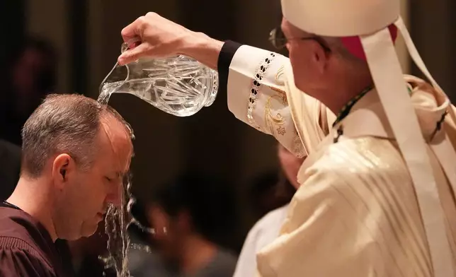 周六（2026年4月4日），天主教大主教保羅．艾蒂安（Archbishop Paul D. Etienne）在西雅圖（Seattle）聖雅各伯座堂（St. James Cathedral）舉行的復活節守夜儀式上為一名人士施洗。（美聯社圖片/Lindsey Wasson） AP圖片