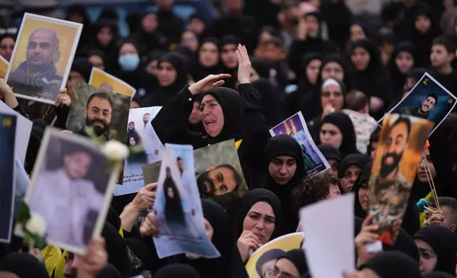 一名女子在黎巴嫩南部卡法西爾（Kfar Sir）村莊舉行的集體葬禮上哀悼，其他人則手持在真主黨與以色列戰爭停火前陣亡的真主黨戰士肖像。攝於2026年4月21日周二。(美聯社圖片/Hassan Ammar) AP圖片