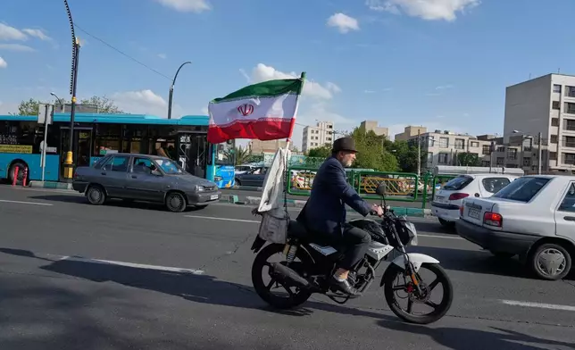 一名男子在伊朗德黑蘭南部騎著裝飾有伊朗國旗的電單車。攝於2026年4月21日周二。(美聯社圖片/Vahid Salemi) AP圖片