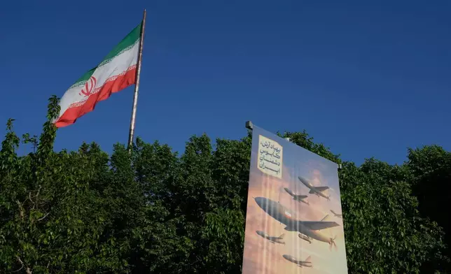 在伊朗德黑蘭，一面橫幅展示了伊朗製造的無人機圖案，上面用波斯語寫著：「阿拉什無人機是伊朗敵人的噩夢」，左側則飄揚著伊朗國旗。攝於2026年4月21日周二。(美聯社圖片/Vahid Salemi) AP圖片