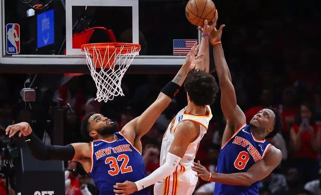 2026年4月23日周四，鷹隊前鋒謝倫莊臣（中）在亞特蘭大舉行的NBA季後賽首圈第三場賽事下半場，面對紐約人中鋒卡爾安東尼唐斯（32號）及前鋒阿奴諾比（8號）起手投籃。(美聯社圖片/Colin Hubbard) AP圖片