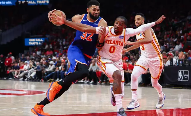 2026年4月23日周四，紐約人中鋒卡爾安東尼唐斯（32號）在亞特蘭大舉行的NBA季後賽首圈第三場賽事下半場，突破鷹隊前鋒莊拿芬古明加（0號）上籃。(美聯社圖片/Colin Hubbard) AP圖片