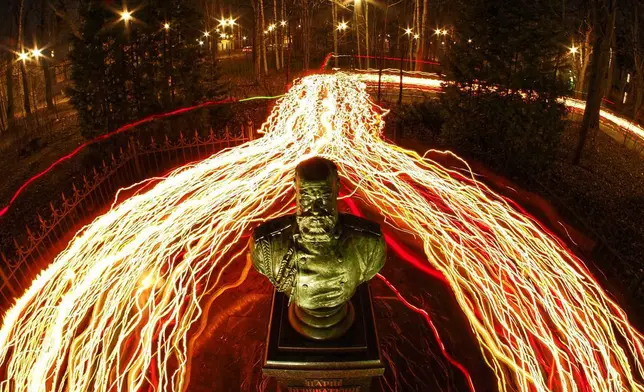 2026年4月12日周日，俄羅斯聖彼得堡（St. Petersburg），東正教信徒在東正教復活節午夜禮拜期間，手持蠟燭走過教堂附近安裝的俄羅斯沙皇亞歷山大三世（Alexander III）半身像。(美聯社圖片/Dmitri Lovetsky) AP圖片