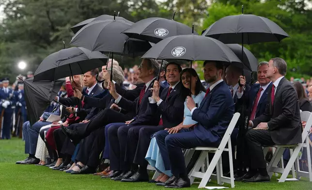 2026年4月28日周二，華盛頓白宮南草坪舉行的歡迎儀式上，美國及英國代表團成員撐傘。(美聯社圖片/Julia Demaree Nikhinson) AP圖片
