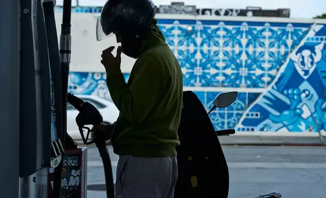 2026年4月17日周五，尼爾馬利克（Neer Malik）在洛杉磯一間油站為其電單車加注一加侖汽油，以行駛約160公里。(美聯社圖片/Damian Dovarganes) AP圖片