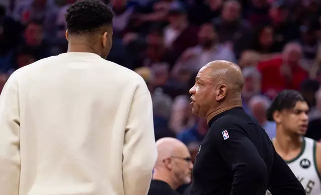 周日（2026年4月12日），密爾沃基公鹿主教練道格·里弗斯（Doc Rivers）（前右）在費城舉行的NBA籃球賽上半場，與大前鋒揚尼斯·安迪度高普（Giannis Antetokounmpo）（左）交談。(美聯社圖片/Chris Szagola) AP圖片