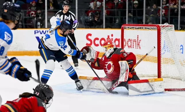2026年4月25日周六，加拿大安大略省渥太華，職業女子冰球聯賽（PWHL）賽事第二節，渥太華衝鋒隊（Ottawa Charge）門將菲臘絲（Gwyneth Philips，33號）在多倫多權杖隊（Toronto Sceptres）的費絲特（Renata Fast，14號）施壓下，嘗試撲救。(Spencer Colby/The Canadian Press via AP) AP圖片