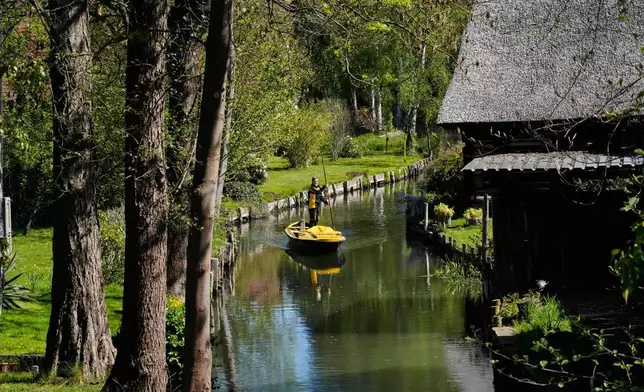 2026年4月29日周三，德國呂貝瑙（Luebbenau）萊德村，郵差安德里亞·布納爾（Andrea Bunar）站在船上，利用一支長槳划船、掌舵，在狹窄水道中航行，進行夏季首次水路郵件派遞。 (美聯社圖片/馬庫斯·施賴伯 Markus Schreiber) AP圖片