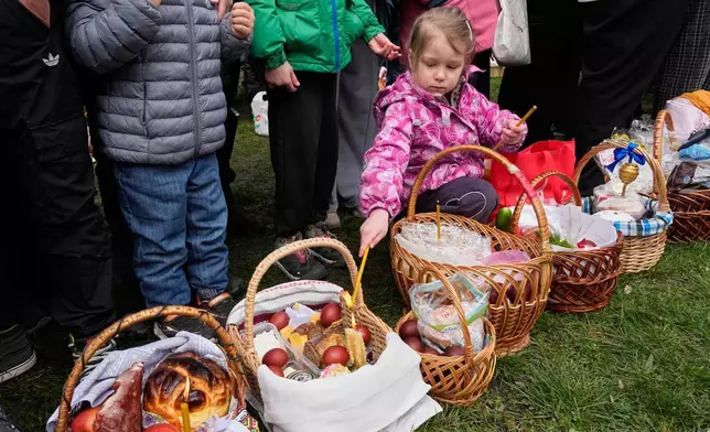 一名小女孩點燃蠟燭，民眾在烏克蘭基輔附近的皮羅希夫，為復活節籃子祈福，慶祝東正教復活節。攝於2026年4月12日周日。(美聯社圖片/Efrem Lukatsky) AP圖片