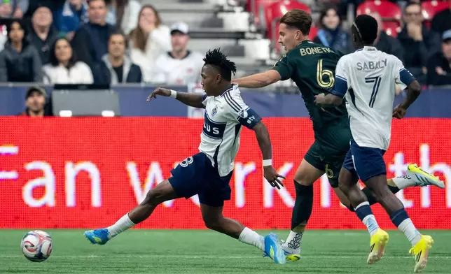 溫哥華白帽的艾迪亞奧甘普（18號）在2026年4月4日周六於卑詩省溫哥華舉行的一場美職聯足球賽上半場入球，隊友沙巴利（7號）及波特蘭伐木者的邦尼迪格（6號）在旁觀看。(Ethan Cairns/The Canadian Press via AP) AP圖片