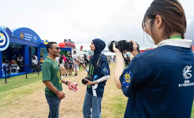 「香港賽馬會青少年體育記者培訓計劃」的學員在「七欖」賽事現場採訪馬會騎師田泰安（左）。