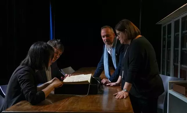 二零二六年五月八日周四，都柏林聖三一學院的伊利沙伯塔·馬格南蒂（左起）、馬克·福克納，以及羅馬國家中央圖書館的安德烈亞·卡帕和華倫蒂娜·隆戈，在羅馬國家中央圖書館檢視一份手稿，該手稿收錄了罕見且失傳已久的《卡德蒙讚美詩》——首部以古英語寫成的詩歌。(美聯社圖片/Andrea Rosa) AP圖片