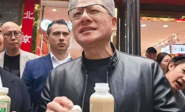 黃仁勳當天在北京知名景點南鑼鼓巷邊逛邊吃，吸引大量民眾圍觀合影。微博圖片