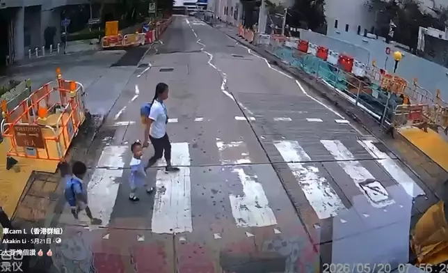 一名女傭帶着兩名身穿校服的幼童橫過斑馬線。車cam L（香港群組）FB群組視頻截圖