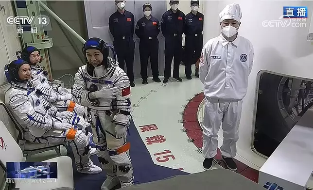 神舟二十三號航天員黎家盈進入軌道艙前，手指指向航天服上的國旗標誌。央視視頻截圖