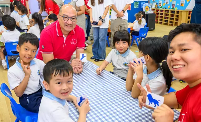 馬會公司事務執行總監譚志源（後排紅衣）夥義工帶領幼稚園學童，一起將二手玩具創作成獨一無二的玩具畫，延長被遺棄玩具的生命，並教育小朋友珍惜玩具。