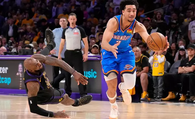 2026年5月11日周一，洛杉磯，NBA季後賽第二圈第四場下半場，奧克拉荷馬雷霆後衛麥堅（右）運球衝向籃筐，洛杉磯湖人前鋒勒邦占士倒地。(美聯社圖片/Mark J. Terrill) AP圖片
