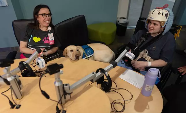 2026年5月4日周一，辛辛那提兒童醫院兒童生活專員奧格雷迪（左）與駐院犬格羅弗（中），在醫院的西克雷斯特工作室與病人霍奇合作，製作一個傳送至病房的閉路電視節目。(美聯社圖片/Carolyn Kaster) AP圖片