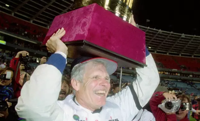 資料圖片：1995年10月28日，亞特蘭大勇士隊（Atlanta Braves）老闆泰德特納（Ted Turner）在亞特蘭大富爾頓縣體育場（Atlanta Fulton County Stadium）舉起世界大賽獎盃，當時勇士隊贏得1995年世界大賽冠軍。(美聯社圖片/John Bazemore) AP圖片