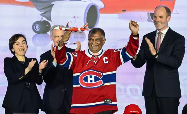 2026年5月6日周三，在魁北克（Quebec）米拉貝爾（Mirabel）的空中巴士A220交付中心一項活動上，亞洲航空（AirAsia）簽署了150架空中巴士A220客機的里程碑式訂單。圖為（左起）魁北克省省長克莉絲汀費雪特（Christine Frechette）、加拿大總理馬克卡尼（Mark Carney）及空中巴士商用飛機行政總裁拉爾斯華格納（Lars Wagner）鼓掌，亞洲航空行政總裁東尼費南迪斯（Tony Fernandes）（中）在場。(美聯社圖片/Graham Hughes/The Canadian Press) AP圖片
