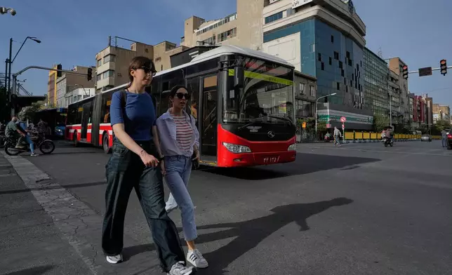 2026年5月28日周四，伊朗德黑蘭市中心一個路口，有婦女步行，一輛公共巴士駛過。(美聯社圖片/Vahid Salemi) AP圖片