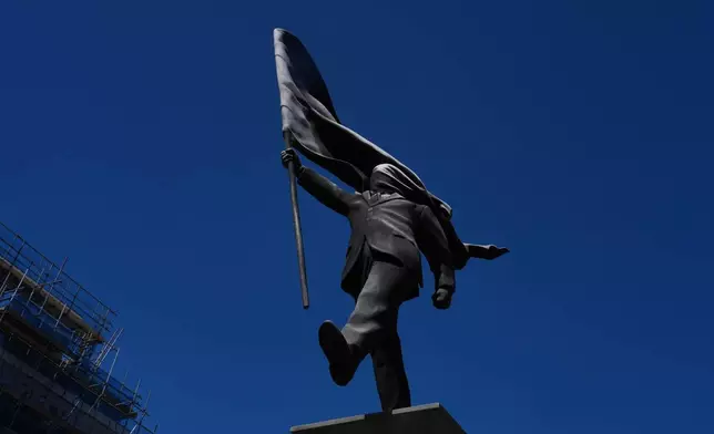 倫敦滑鐵盧廣場（Waterloo Place）周四（2026年4月30日）出現一座雕塑，描繪一名男子手持旗幟遮蓋臉部，並簽有「Banksy」字樣。（美聯社圖片/Kin Cheung） AP圖片