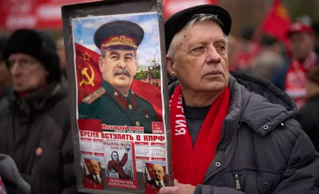 2026年5月1日周五，一名男子手持印有前蘇聯領袖史太林（Josef Stalin）肖像的海報，他與其他俄羅斯共產黨支持者在莫斯科紅場附近、19世紀德國哲學家馬克思（Karl Marx）的紀念碑前聚集，紀念勞動節，又稱五一勞動節。(美聯社圖片/Alexander Zemlianichenko) AP圖片