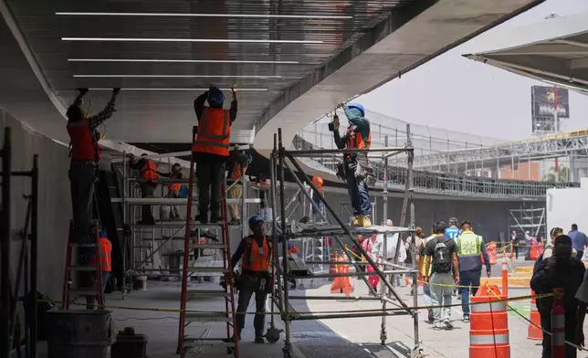 工人於2026年5月19日周二，在墨西哥城貝尼托華雷斯國際機場進行翻新工程的傳媒導覽期間，維修一號客運大樓的天花，為2026年世界盃作準備。(美聯社圖片/Fernando Llano) AP圖片