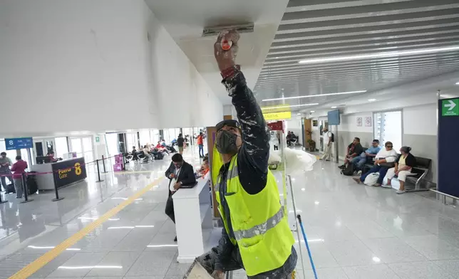 一名工人於2026年5月19日周二，在墨西哥城貝尼托華雷斯國際機場進行翻新工程的傳媒導覽期間，粉刷一號客運大樓的天花，為2026年世界盃作準備。(美聯社圖片/Fernando Llano) AP圖片